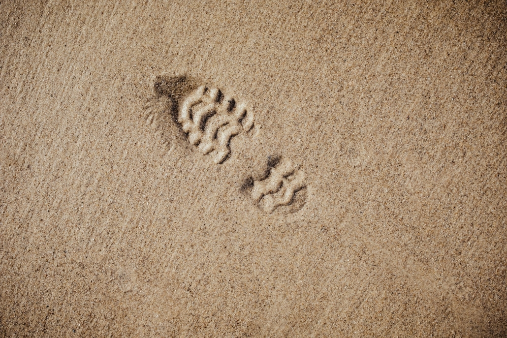 a shoeprint left behind on a beach